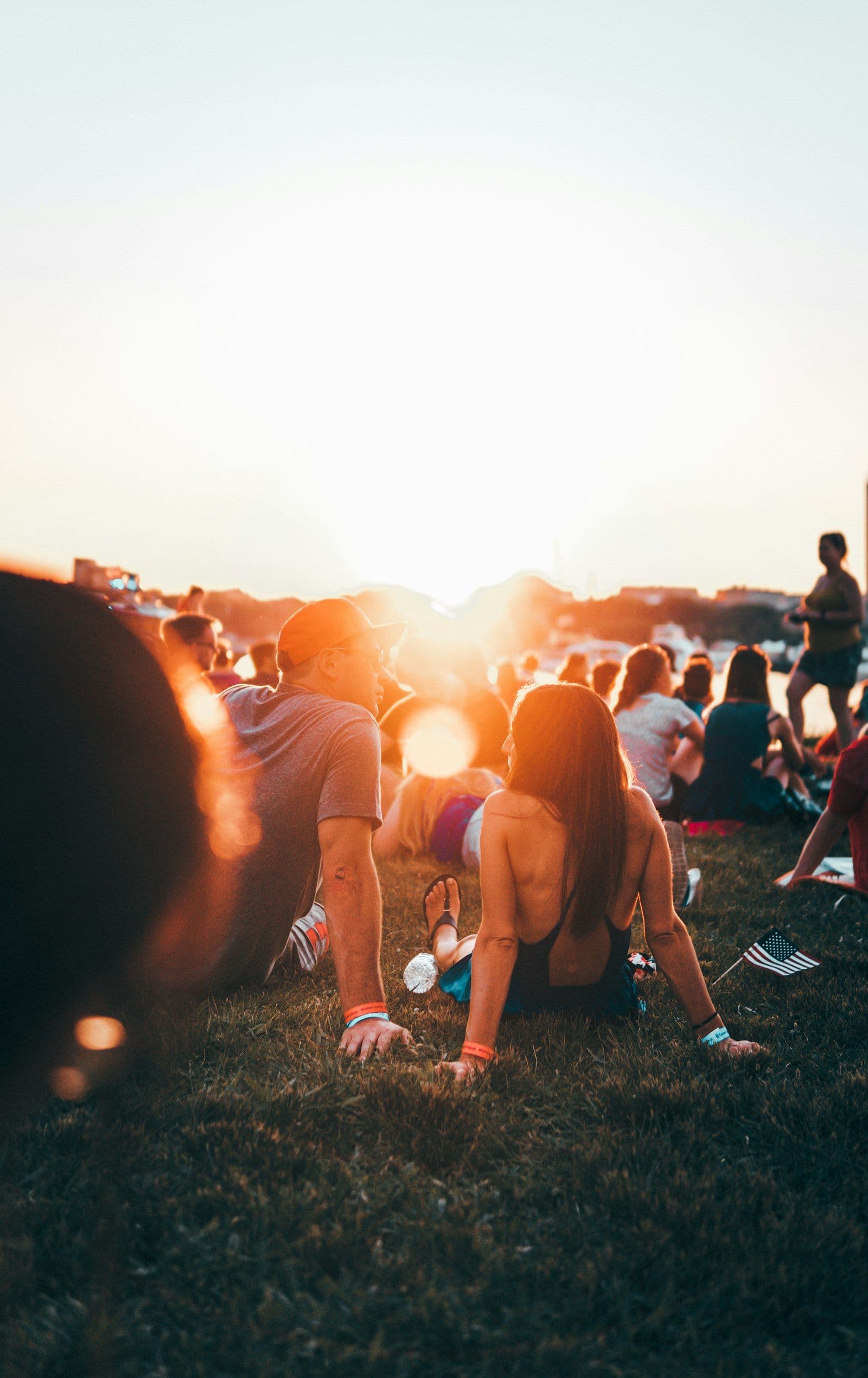 Two people sitting on the grass in low golden evening light